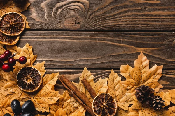 Top view of autumnal decoration and foliage on brown wooden background — Stock Photo