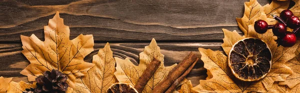 Top view of autumnal decoration and foliage on brown wooden background, panoramic shot — Stock Photo