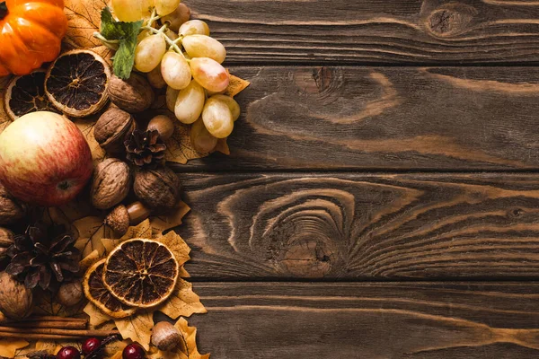 Top view of autumnal harvest and decoration on brown wooden background — Stock Photo