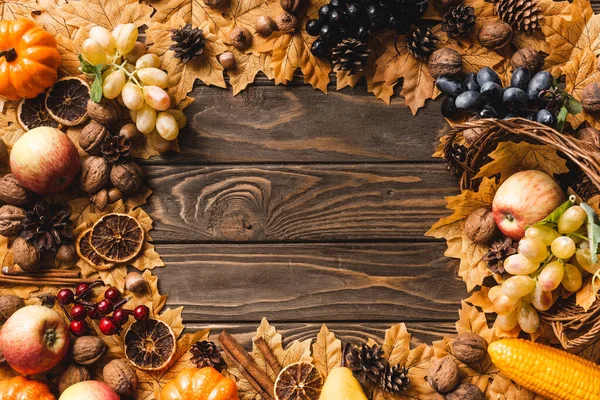 Vista dall'alto di cornice rotonda fatta di raccolta autunnale e fogliame su sfondo di legno marrone — Foto stock