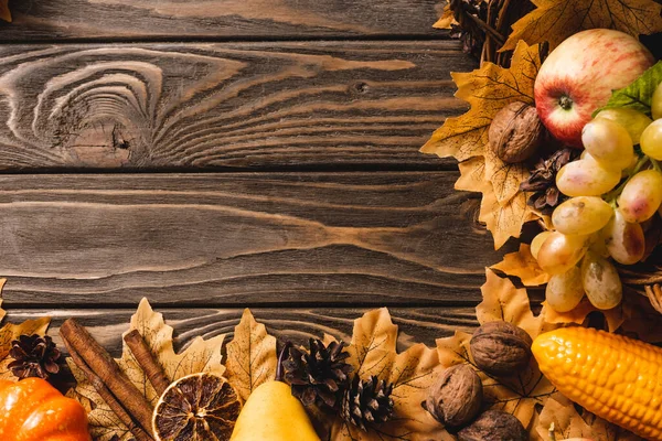Верхний вид осеннего урожая и украшения на коричневом деревянном фоне — стоковое фото