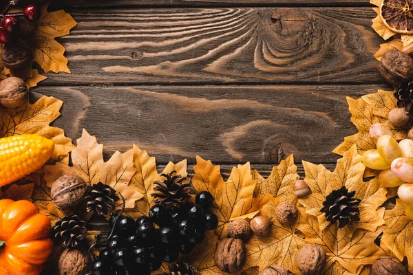 Верхний вид осеннего урожая и листвы на коричневом деревянном фоне — стоковое фото