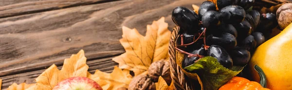 Осенний урожай в корзине на листве на коричневом деревянном фоне, панорамный снимок — стоковое фото