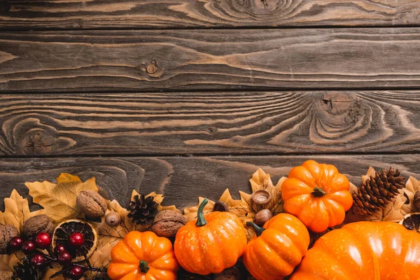 Vista dall'alto della decorazione autunnale e zucche su sfondo di legno marrone — Foto stock