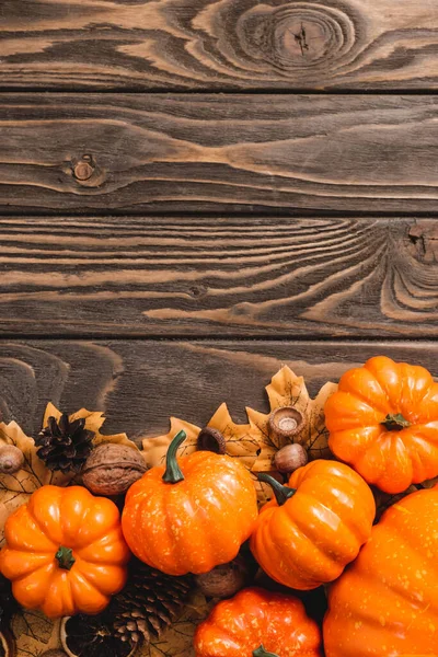 Vista dall'alto della decorazione autunnale e zucche su sfondo di legno marrone — Foto stock