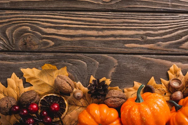 Vista superior de la decoración otoñal y calabazas sobre fondo de madera marrón - foto de stock