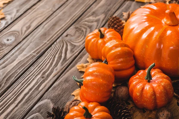 Autumnal decoration and pumpkins on brown wooden background — Stock Photo