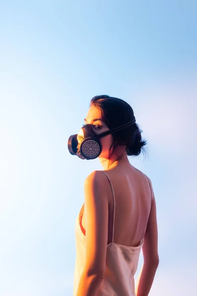 Brunette femme en masque à gaz debout sur bleu — Photo de stock