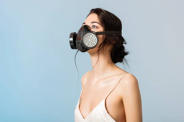 Morena mujer en máscara de gas mirando hacia arriba aislado en gris, concepto de ecología - foto de stock