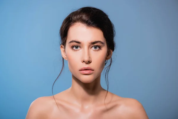 Young and naked woman looking at camera isolated on blue — Stock Photo