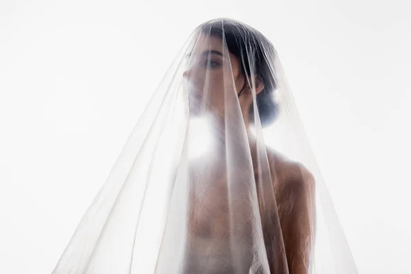 Брюнетка женщина покрыта полиэтиленом глядя в сторону изолированы на белом, экология концепции — стоковое фото