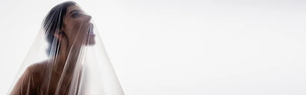 Horizontales Bild einer brünetten Frau, die durch Polyethylen schreit, isoliert auf Weiß, ökologisches Konzept — Stockfoto