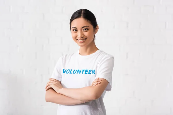 Asian volunteer with crossed arms looking at camera — Stock Photo