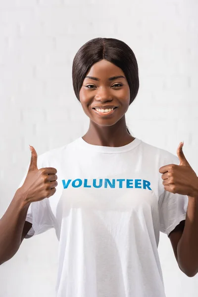 African american volunteer showing thumbs up in charity center — Stock Photo