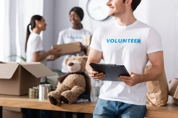 Selective focus of volunteer holding clipboard and pen in charity center — Stock Photo