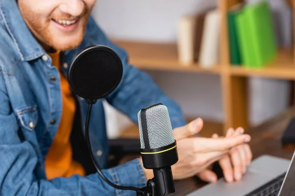 Cropped view of excited announcer gesturing while speaking in microphone at workplace — Stock Photo