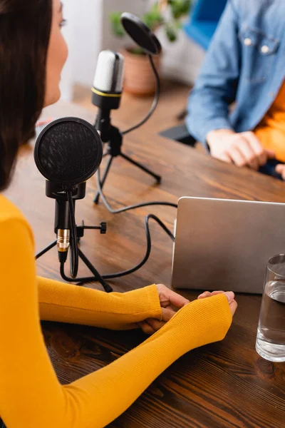 Cropped view of broadcaster interviewing woman in radio studio — Stock Photo