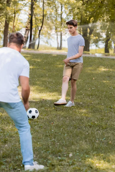 Enfoque selectivo de hijo adolescente jugando al fútbol con el padre — Stock Photo