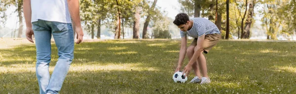 Raccolto panoramico di ragazzo adolescente che gioca a calcio con il padre — Foto stock