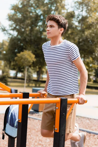 Adolescent sportif garçon exercice sur barres horizontales — Photo de stock