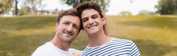 Horizontal image of father and teenager son in park — Stock Photo