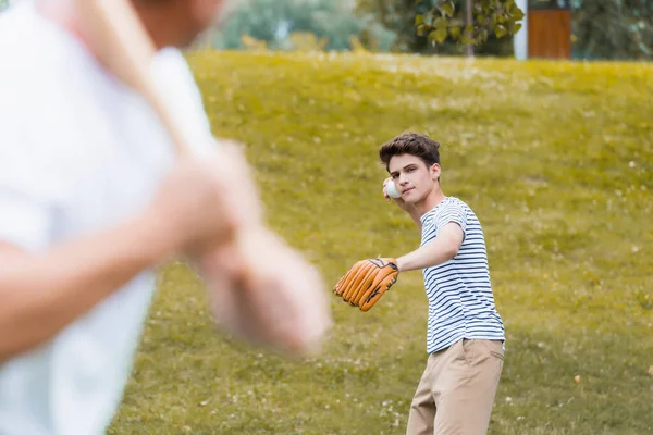 Foco seletivo do menino adolescente em luva de couro segurando bola enquanto joga beisebol com o pai — Fotografia de Stock