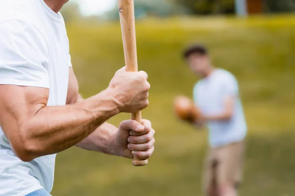 Corte vista de homem segurando softball morcego perto adolescente menino — Fotografia de Stock