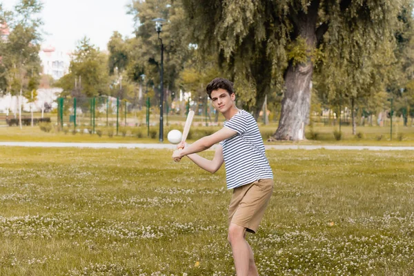 Adolescente menino segurando softball morcego e jogar beisebol no parque — Fotografia de Stock