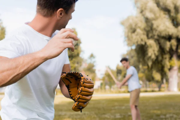 Enfoque selectivo del hombre en guante de cuero jugando béisbol con hijo adolescente en el parque - foto de stock