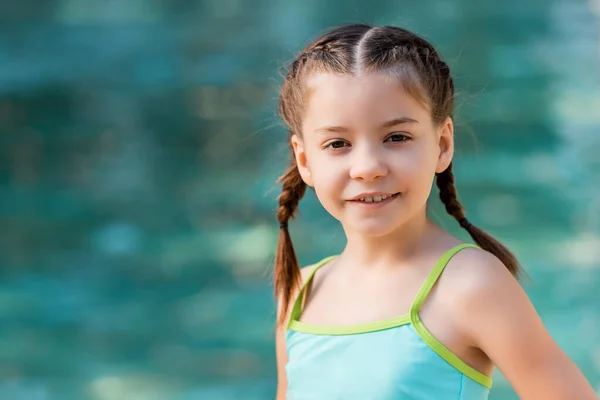 Fille avec des tresses, portant un maillot de bain, regardant la caméra — Photo de stock