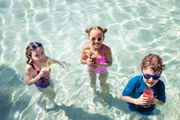 Vista de ángulo alto de amigos alegres beber cócteles de frutas frescas en la piscina - foto de stock