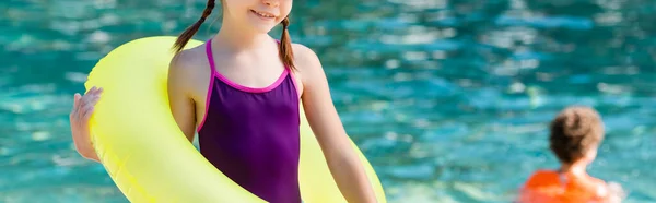 Vue recadrée de la fille en maillot de bain tenant anneau gonflable, image horizontale — Photo de stock