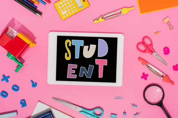 Top view of digital tablet with student lettering on screen near school stationery on pink — Stock Photo