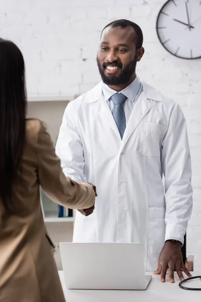 Вибірковий фокус афроамериканського лікаря стоїть і дивиться на пацієнта — стокове фото