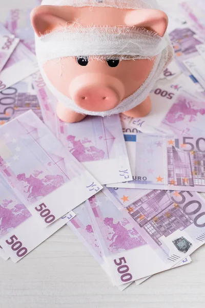 Hochwinkelblick auf Sparschwein mit Binde am Geld — Stockfoto