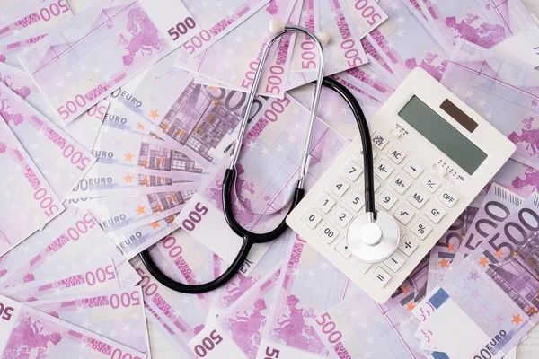 Top view of white calculator and stethoscope on euro banknotes — Stock Photo