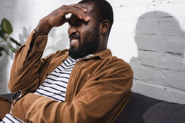 Concentration sélective de l'homme afro-américain ayant mal à la tête — Photo de stock