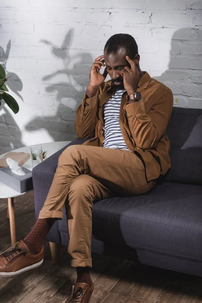 Enfoque selectivo del hombre afroamericano con los ojos cerrados tocando la cara - foto de stock