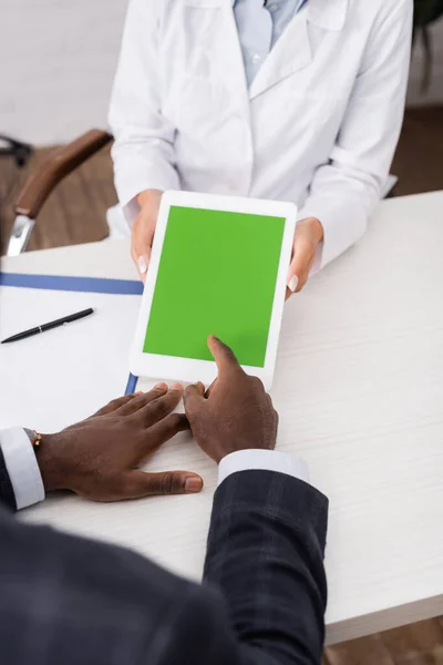 Visão cortada do homem americano africano apontando com o dedo para tablet digital com tela verde perto do médico — Fotografia de Stock