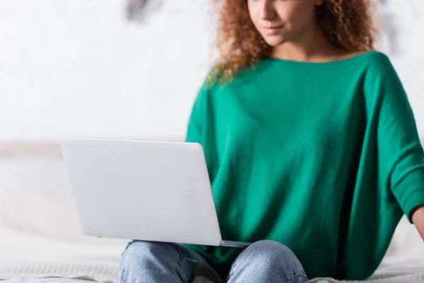 Foco seletivo da jovem mulher usando laptop no quarto — Fotografia de Stock