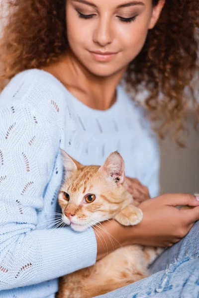 Concentration sélective de la femme tenant chat tabby à la maison — Photo de stock