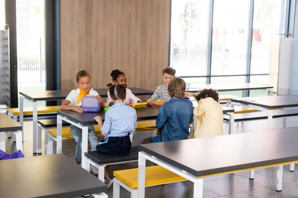 Мультикультурні учні сидять у шкільній їдальні під час гальмування обіду — стокове фото