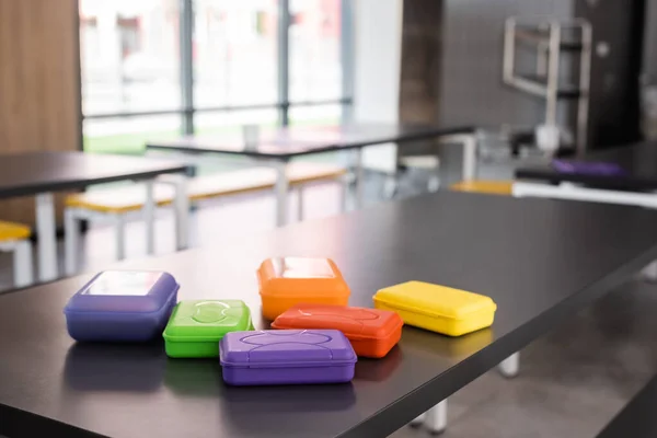 Bunte Plastik-Brotdosen auf dem Tisch in der Schulmensa — Stockfoto