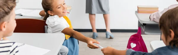 Messa a fuoco selettiva della scolaretta prendendo nota dalla compagna di classe durante la lezione, concetto orizzontale — Foto stock