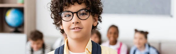 Vue panoramique de l'écolier musulman regardant la caméra dans la salle de classe — Photo de stock