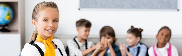 Horizontale Ernte von Schulmädchen blickt in die Kamera in der Nähe mltiethnischer Klassenkameraden — Stockfoto