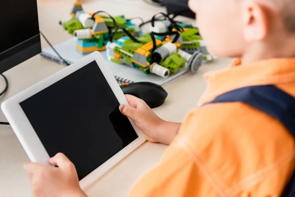Cropped view of schoolboy holding digital tablet in stem school — Stock Photo