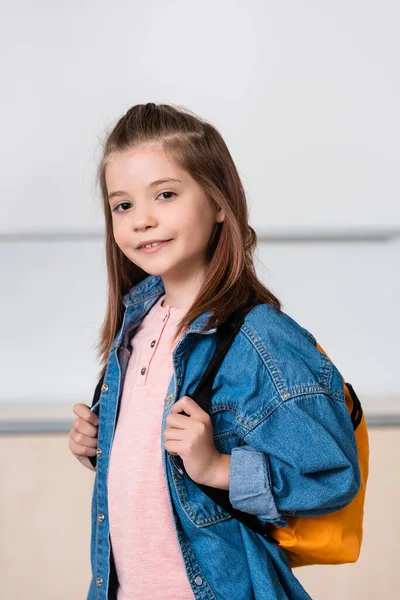 Schoolgirl with backpack looking at camera in classroom of stem school — Stock Photo