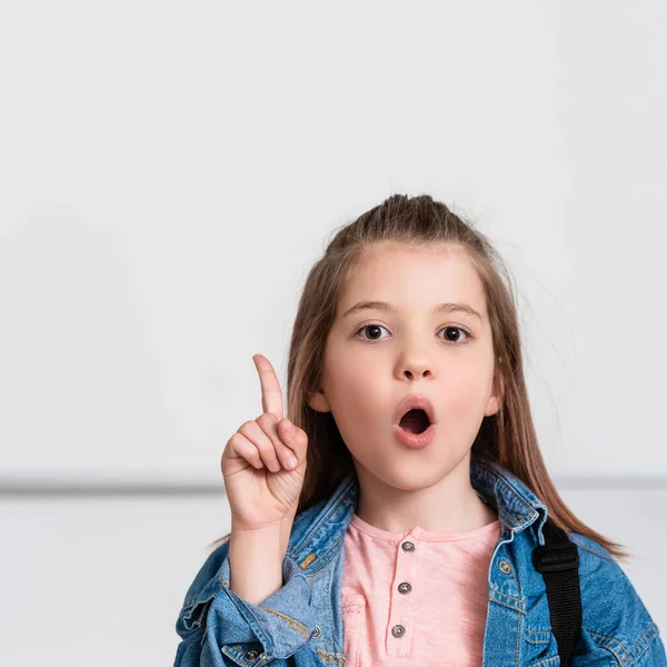 Écolière excitée ayant idée tout en regardant la caméra dans l'école tige — Photo de stock