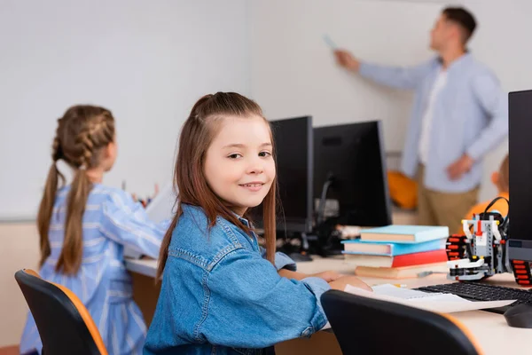 Focus selettivo della studentessa che guarda la fotocamera durante la lezione nella scuola staminale — Foto stock